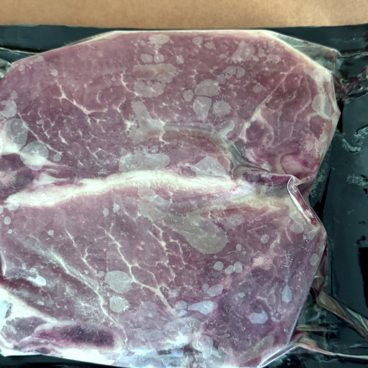 Two bone-in pasture-raised pork loin chops, vacuum sealed